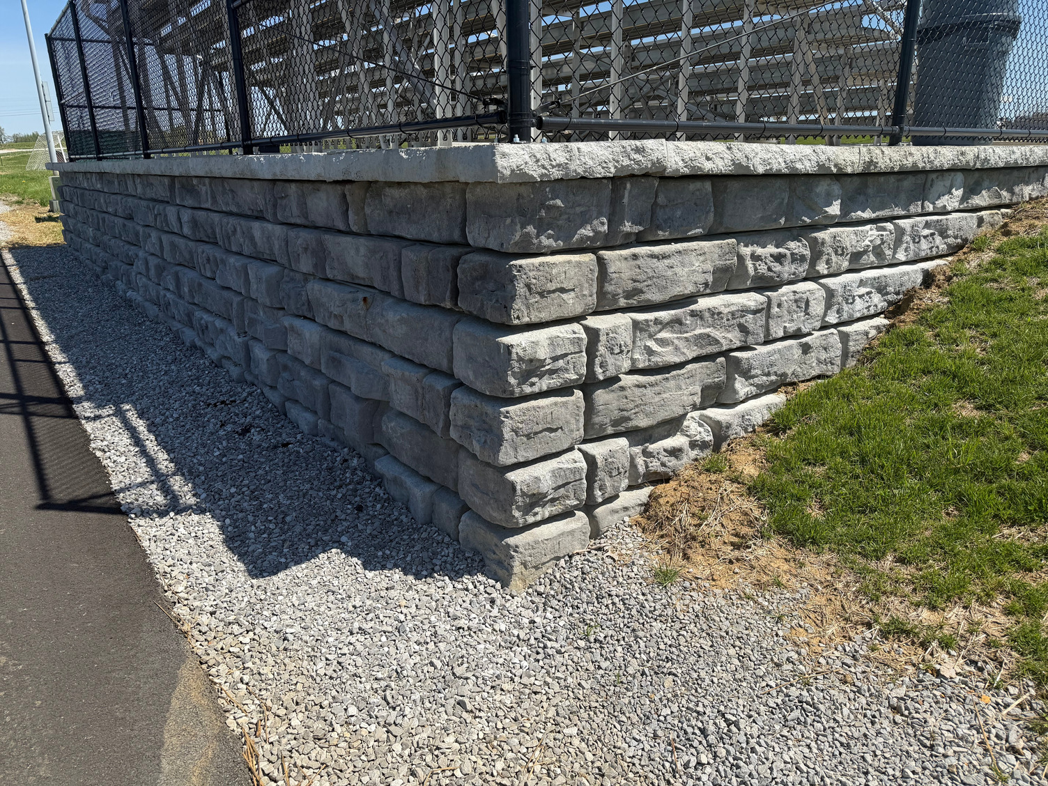 Modular retaining wall supporting a raised roadside area